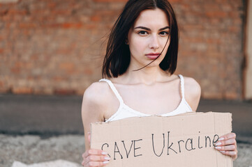Close-up portrait of a young woman with bob on the background of a brick wall.