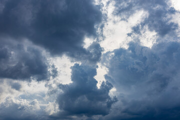 blue skylight with light among dark clouds