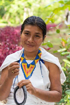 Beautiful shot of a young indigenous woman from the Sierra Nevada de Santa Marta, smiling looking at the camera.