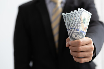 A businessman showing a roll of banknotes is giving.