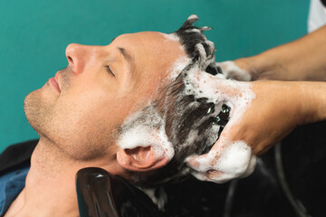 Naklejka premium male head washing in hairdressing salon
