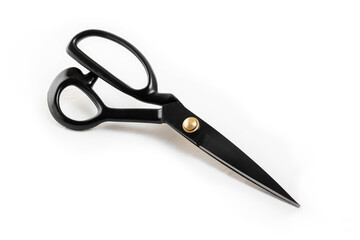 Black tailor's scissors lie on a white background. Close-up. Copy space