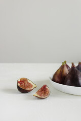 Fresh figs on the white plate on the gray background in minimalism style