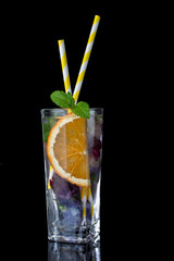 Glass with ice, cold water fresh mint and edible flowers