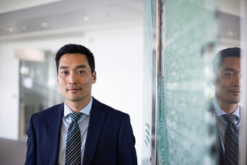 Portrait of Asian businessman with reflection in a modern corporate office
