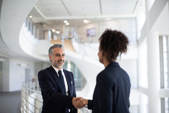 Middle Eastern businessman shaking hands with a businesswoman
