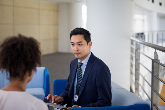 Asian businessman interviewing businesswoman using a digital tablet