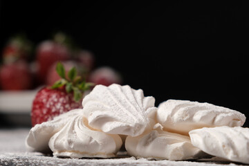 Meringue close up and strawberries in a plate on a black background. Fruit desserts.