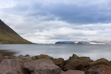 Hills with grazing Icelandic sheep next to a lake and volcano crater