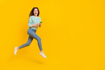 Fototapeta na wymiar Full body image of cute cheerful girl chatting in phone receive many likes on her photo isolated on yellow color background