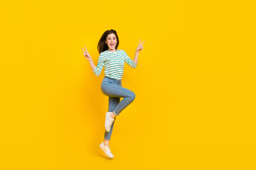 Fototapeta na wymiar Full size photo of cheerful overjoyed female jumping showing v-sign say hello hi isolated on yellow color background