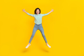 Fototapeta na wymiar Full size photo of cheerful good mood rejoiced girl jumping have fun during vacation isolated on yellow color background