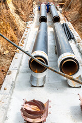 Construction works on large iron pipes at a depth of excavated trench - 512561846