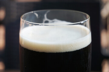Glass of dark beer, defocused background