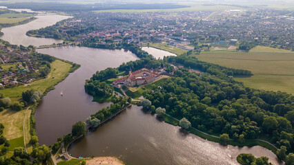 Fototapeta na wymiar Aerial view of Nesvizh Castle and river, Belarus. Medieval castle and palace. Restored medieval fortress.