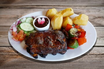 Barbecued spareribs with tomatoes and salad