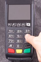 Fototapeta na wymiar Hand of woman using credit card reader to enter PIN code. Cashless paying. Finance and banking