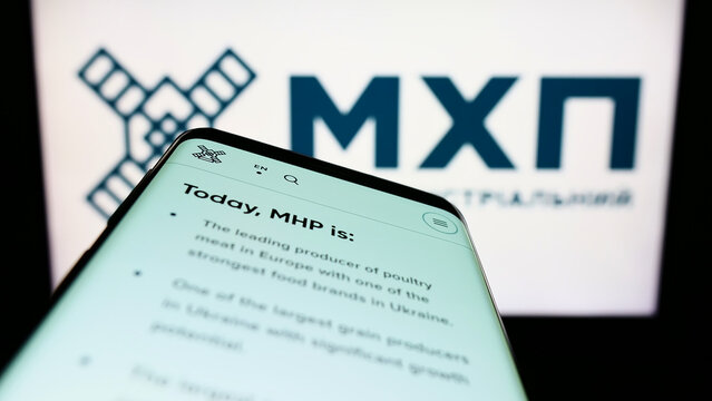 Stuttgart, Germany - 06-18-2022: Smartphone with webpage of Ukrainian company Myronivsky Hliboproduct (MHP) on screen in front of logo. Focus on top-left of phone display.