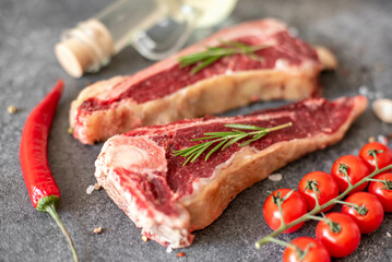 Raw steak "New York" on the bone with rosemary and spices. 