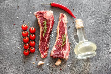 Raw steak "New York" on the bone with rosemary and spices. 