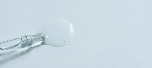 Pipette with fluid serum, oil, face gel cleaner. Cosmetics and healthcare concept closeup. Dose of retinol with air bubbles. Flat lay. Monkeypox, coronavirus research