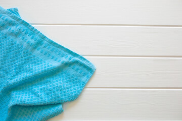A blue terry towel lies on a white wooden table. Cleanliness and hygiene. Bathroom. Sun lounger by the pool, spa treatments.