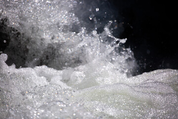 Drops of water, splashing and bubbling waterfall as a background. Foam party or laundry. The concept of freshness of soft drinks.