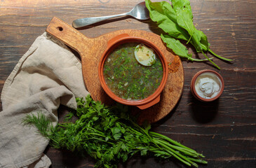 Soup of fresh herbs with sour cream and boiled egg. Summer soup of sorrel or spinach.