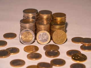 Close-up piled up euro coins. Stacked one euro, two euro and fifty cent coins. European currency. 