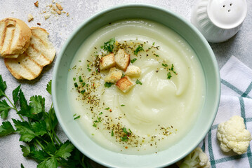 Vegetarian cauliflower cream soup with croutons. Top view with copy space.