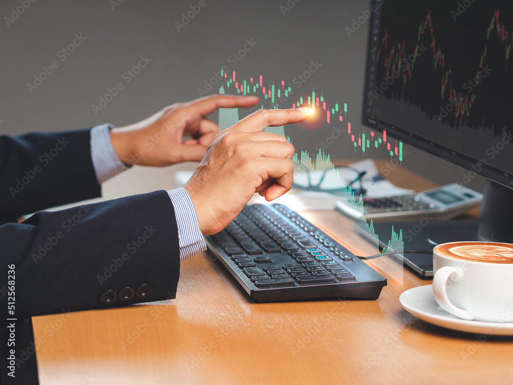 Poster hand of a businessman pointing to graph stock on a virtual screen while sitting in the office