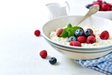Oatmeal porridge with fresh berries for a breakfast.
