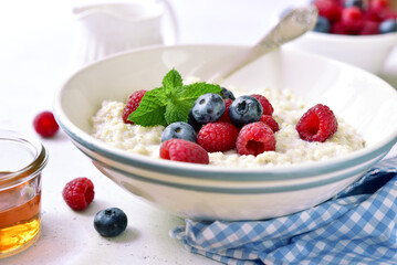 Oatmeal porridge with fresh berries for a breakfast.