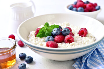 Oatmeal porridge with fresh berries for a breakfast.