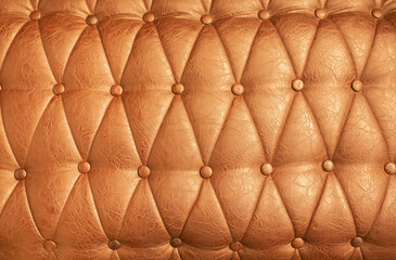 Leather upholstery of a sofa and upholstered furniture as a background or texture for advertising a furniture store. Brown, beige, gold leather for furniture and design.
