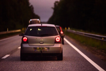 a beautiful car drives in the evening on an asphalt road with a reflector in the window