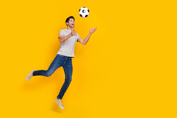 Fototapeta premium Full length body size view of attractive cheerful guy jumping having fun playing game isolated over bright yellow color background