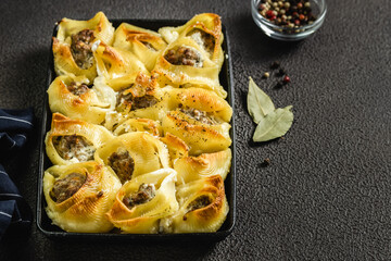 Creamy white wine chicken stuffed pasta shells in cast iron skillet. Top view, copy space, flat lay.