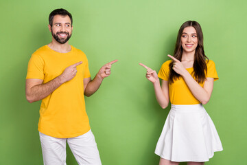 Photo of two cheerful nice people look each other direct fingers isolated on green color background