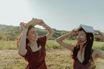 HAPPY GIRLS STUDYING TOGETHER IN THE COUNTRYSIDE. 