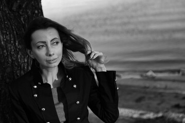 Woman touching her hair near the river in black and white