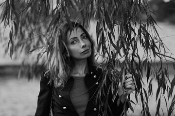 Portrait of a beautiful woman in leaves of a tree in black and white