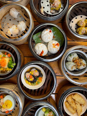 Traditional Dim Sum bamboo baskets with tasty dim sum dishes in Chinese restaurant directly above view