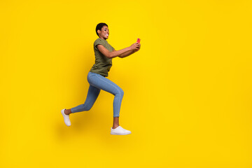 Fototapeta na wymiar Full size portrait of crazy sporty person hold telephone jump rush fast isolated on yellow color background