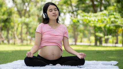 Pregnant woman touching belly in the City Park, Pregnant Relaxing and exercise, Beautiful tender mood photo of pregnancy