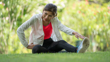 Healty Young female workout exercise before running or fitness training session in City Park. Healthy young woman warming up outdoors. She is stretching her arms at Garden park, Sports and activities