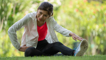 Healty Young female workout exercise before running or fitness training session in City Park. Healthy young woman warming up outdoors. She is stretching her arms at Garden park, Sports and activities