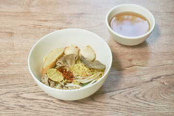 boiled dry Chenese yellow egg noodles with entrails and meatball on bowl 