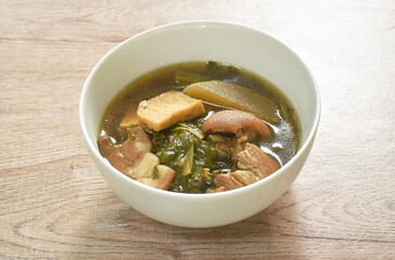 boiled mixed vegetable with pork belly and tofu in black soybean soup in bowl 