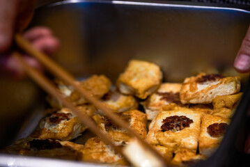 A chef is making pan-fried tofu stuffed meat